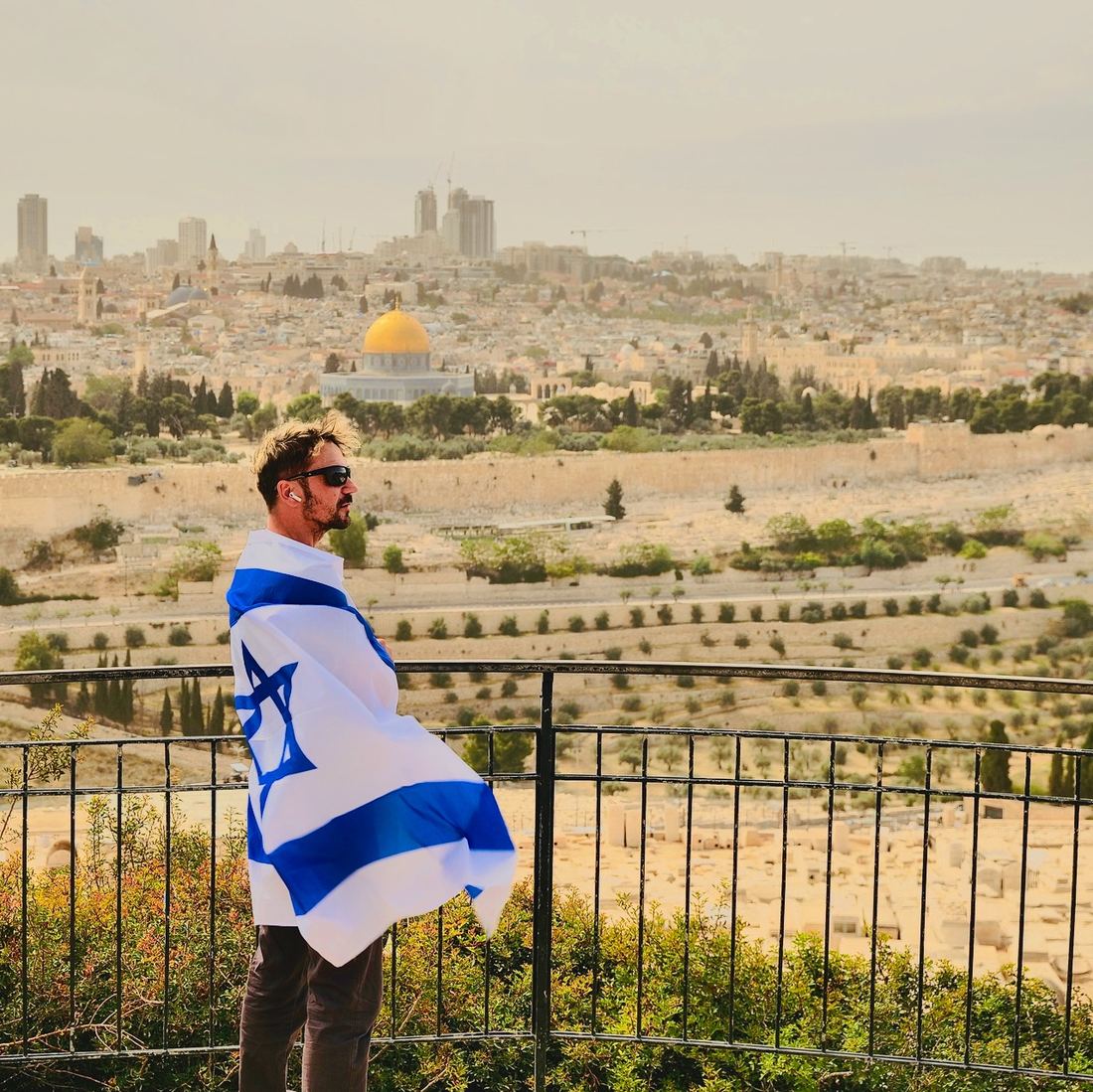 With the flag of Israel at a Jerusalem viewpoint
