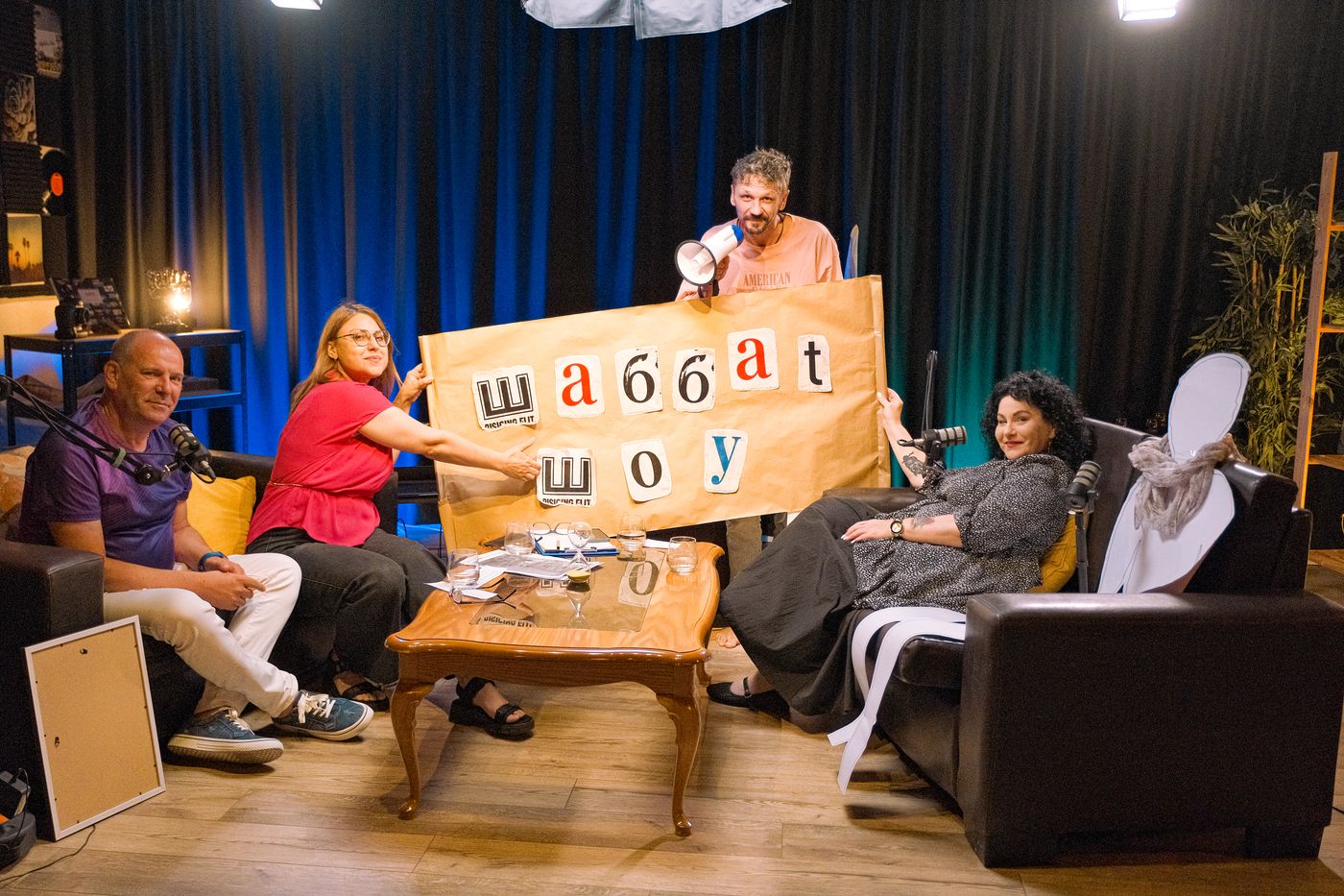 Filming a Shabbat Show episode — the team holds up a banner